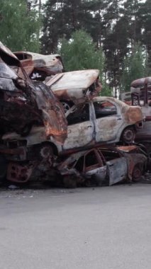 Bu stok dikey video Irpin, Bucha bölgesinde bir kurşun ve yanmış araba dökümü gösteriyor.