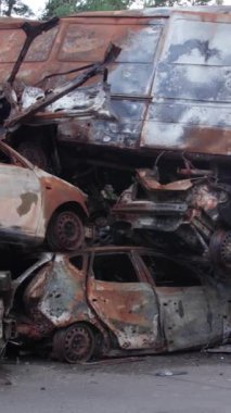 Bu stok dikey video Irpin, Bucha bölgesinde bir kurşun ve yanmış araba dökümü gösteriyor.