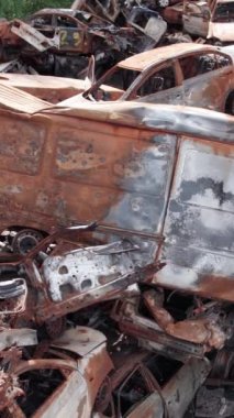Bu stok dikey video Irpin, Bucha bölgesinde bir kurşun ve yanmış araba dökümü gösteriyor.