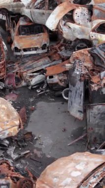 Bu stok dikey video Irpin, Bucha bölgesinde bir kurşun ve yanmış araba dökümü gösteriyor.