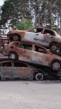 Bu stok dikey video Irpin, Bucha bölgesinde bir kurşun ve yanmış araba dökümü gösteriyor.