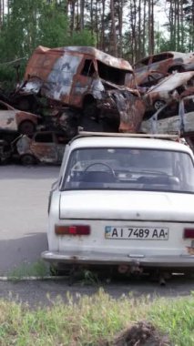 Bu stok dikey video Irpin, Bucha bölgesinde bir kurşun ve yanmış araba dökümü gösteriyor.