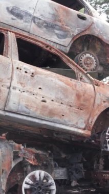 Bu stok dikey video Irpin, Bucha bölgesinde bir kurşun ve yanmış araba dökümü gösteriyor.