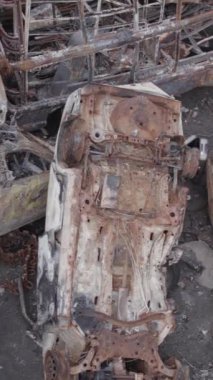 Bu stok dikey video Irpin, Bucha bölgesinde gri, düz, renksiz, yanmış arabaları gösteriyor.