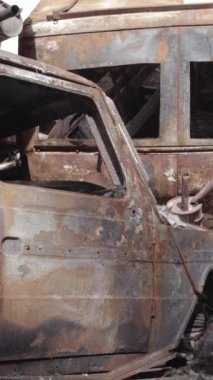 Bu stok dikey video Irpin, Bucha bölgesinde gri, düz, renksiz, yanmış arabaları gösteriyor.
