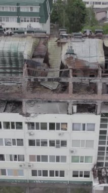 Bu borsa dikey videosu Stoyanka, Bucha bölgesinde, Ukrayna 'da, gri, renksiz, düz bir bina gösteriyor.