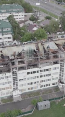 Bu borsa dikey videosu Stoyanka, Bucha bölgesinde, Ukrayna 'da, gri, renksiz, düz bir bina gösteriyor.