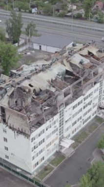 Bu borsa dikey videosu Stoyanka, Bucha bölgesinde, Ukrayna 'da, gri, renksiz, düz bir bina gösteriyor.