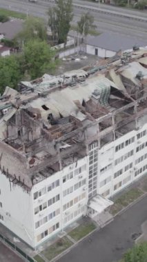 Bu borsa dikey videosu Stoyanka, Bucha bölgesinde, Ukrayna 'da, gri, renksiz, düz bir bina gösteriyor.