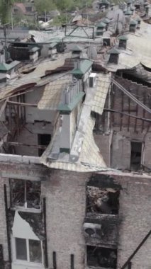 Bu borsa dikey videosu Stoyanka, Bucha bölgesinde, Ukrayna 'da, gri, renksiz, düz bir bina gösteriyor.