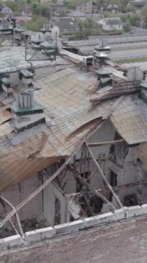 Bu borsa dikey videosu Stoyanka, Bucha bölgesinde, Ukrayna 'da, gri, renksiz, düz bir bina gösteriyor.