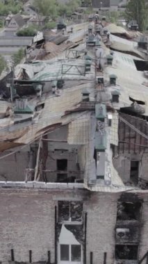 Bu borsa dikey videosu Stoyanka, Bucha bölgesinde, Ukrayna 'da, gri, renksiz, düz bir bina gösteriyor.