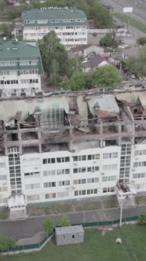 Bu borsa dikey videosu Stoyanka, Bucha bölgesinde, Ukrayna 'da, gri, renksiz, düz bir bina gösteriyor.