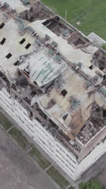 Bu borsa dikey videosu Stoyanka, Bucha bölgesinde, Ukrayna 'da, gri, renksiz, düz bir bina gösteriyor.