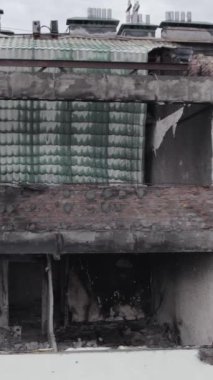 Bu borsa dikey videosu Stoyanka, Bucha bölgesinde, Ukrayna 'da, gri, renksiz, düz bir bina gösteriyor.