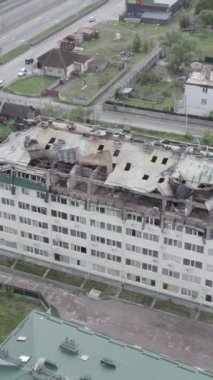 Bu borsa dikey videosu Stoyanka, Bucha bölgesinde, Ukrayna 'da, gri, renksiz, düz bir bina gösteriyor.