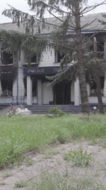 Bu dikey video Ukrayna 'daki savaşın sonucunu gösteriyor. Borodyanka, Kyiv bölgesindeki polis karakolunun yıkılmış ve yanmış binası. Gri, renksiz, düz.