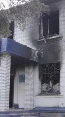 Bu dikey video Ukrayna 'daki savaşın sonucunu gösteriyor. Borodyanka, Kyiv bölgesindeki polis karakolunun yıkılmış ve yanmış binası. Gri, renksiz, düz.
