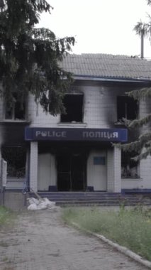 Bu dikey video Ukrayna 'daki savaşın sonucunu gösteriyor. Borodyanka, Kyiv bölgesindeki polis karakolunun yıkılmış ve yanmış binası. Gri, renksiz, düz.