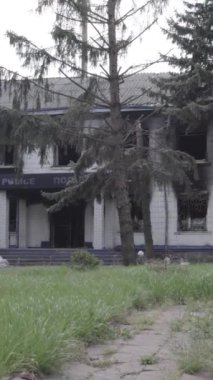 Bu dikey video Ukrayna 'daki savaşın sonucunu gösteriyor. Borodyanka, Kyiv bölgesindeki polis karakolunun yıkılmış ve yanmış binası. Gri, renksiz, düz.