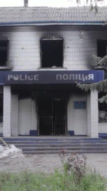 Bu dikey video Ukrayna 'daki savaşın sonucunu gösteriyor. Borodyanka, Kyiv bölgesindeki polis karakolunun yıkılmış ve yanmış binası. Gri, renksiz, düz.