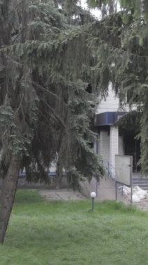 Bu dikey video Ukrayna 'daki savaşın sonucunu gösteriyor. Borodyanka, Kyiv bölgesindeki polis karakolunun yıkılmış ve yanmış binası. Gri, renksiz, düz.