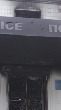 Bu dikey video Ukrayna 'daki savaşın sonucunu gösteriyor. Borodyanka, Kyiv bölgesindeki polis karakolunun yıkılmış ve yanmış binası. Gri, renksiz, düz.