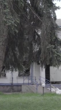 Bu dikey video Ukrayna 'daki savaşın sonucunu gösteriyor. Borodyanka, Kyiv bölgesindeki polis karakolunun yıkılmış ve yanmış binası. Gri, renksiz, düz.