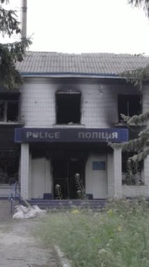 Bu dikey video Ukrayna 'daki savaşın sonucunu gösteriyor. Borodyanka, Kyiv bölgesindeki polis karakolunun yıkılmış ve yanmış binası. Gri, renksiz, düz.
