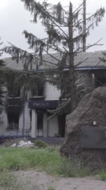 Bu dikey video Ukrayna 'daki savaşın sonucunu gösteriyor. Borodyanka, Kyiv bölgesindeki polis karakolunun yıkılmış ve yanmış binası. Gri, renksiz, düz.