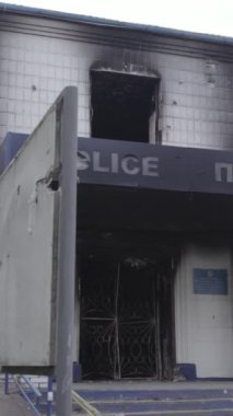 Bu dikey video Ukrayna 'daki savaşın sonucunu gösteriyor. Borodyanka, Kyiv bölgesindeki polis karakolunun yıkılmış ve yanmış binası. Gri, renksiz, düz.