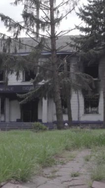 Bu dikey video Ukrayna 'daki savaşın sonucunu gösteriyor. Borodyanka, Kyiv bölgesindeki polis karakolunun yıkılmış ve yanmış binası. Gri, renksiz, düz.