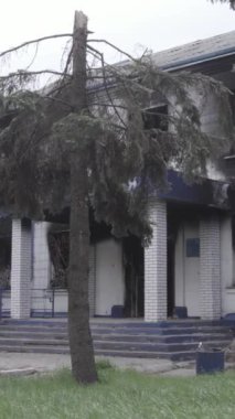 Bu dikey video Ukrayna 'daki savaşın sonucunu gösteriyor. Borodyanka, Kyiv bölgesindeki polis karakolunun yıkılmış ve yanmış binası. Gri, renksiz, düz.