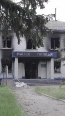 Bu dikey video Ukrayna 'daki savaşın sonucunu gösteriyor. Borodyanka, Kyiv bölgesindeki polis karakolunun yıkılmış ve yanmış binası. Gri, renksiz, düz.