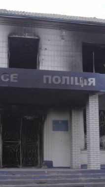 Bu dikey video Ukrayna 'daki savaşın sonucunu gösteriyor. Borodyanka, Kyiv bölgesindeki polis karakolunun yıkılmış ve yanmış binası. Gri, renksiz, düz.