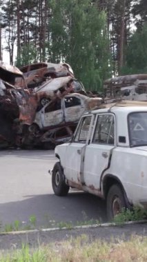 Bu stok dikey video Irpin, Bucha bölgesinde bir kurşun ve yanmış araba dökümü gösteriyor.