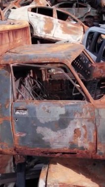 Bu stok dikey video Irpin, Bucha bölgesinde bir kurşun ve yanmış araba dökümü gösteriyor.