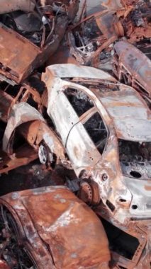 Bu stok dikey video Irpin, Bucha bölgesinde bir kurşun ve yanmış araba dökümü gösteriyor.