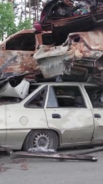 Bu stok dikey video Irpin, Bucha bölgesinde bir kurşun ve yanmış araba dökümü gösteriyor.