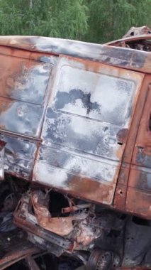 Bu stok dikey video Irpin, Bucha bölgesinde bir kurşun ve yanmış araba dökümü gösteriyor.