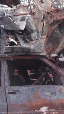 Bu stok dikey video Irpin, Bucha bölgesinde bir kurşun ve yanmış araba dökümü gösteriyor.