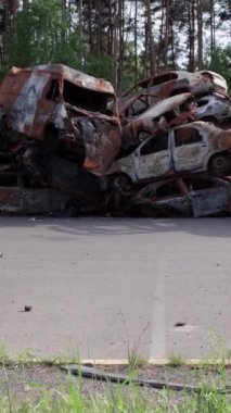 Bu stok dikey video Irpin, Bucha bölgesinde bir kurşun ve yanmış araba dökümü gösteriyor.