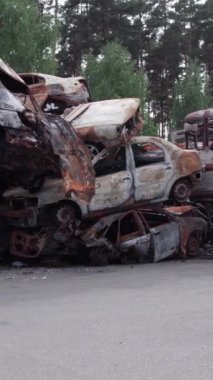 Bu stok dikey video Irpin, Bucha bölgesinde bir kurşun ve yanmış araba dökümü gösteriyor.