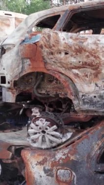 Bu stok dikey video Irpin, Bucha bölgesinde bir kurşun ve yanmış araba dökümü gösteriyor.