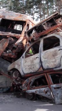 Bu stok dikey video Irpin, Bucha bölgesinde bir kurşun ve yanmış araba dökümü gösteriyor.