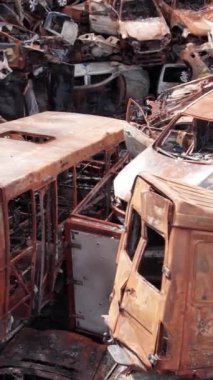 Bu stok dikey video Irpin, Bucha bölgesinde bir kurşun ve yanmış araba dökümü gösteriyor.