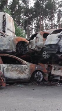 Bu stok dikey video Irpin, Bucha bölgesinde bir kurşun ve yanmış araba dökümü gösteriyor.