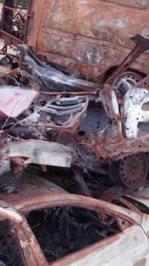 Bu stok dikey video Irpin, Bucha bölgesinde bir kurşun ve yanmış araba dökümü gösteriyor.