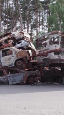 Bu stok dikey video Irpin, Bucha bölgesinde bir kurşun ve yanmış araba dökümü gösteriyor.