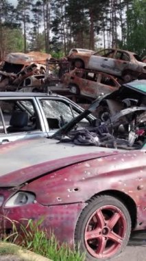 Bu stok dikey video Irpin, Bucha bölgesinde bir kurşun ve yanmış araba dökümü gösteriyor.